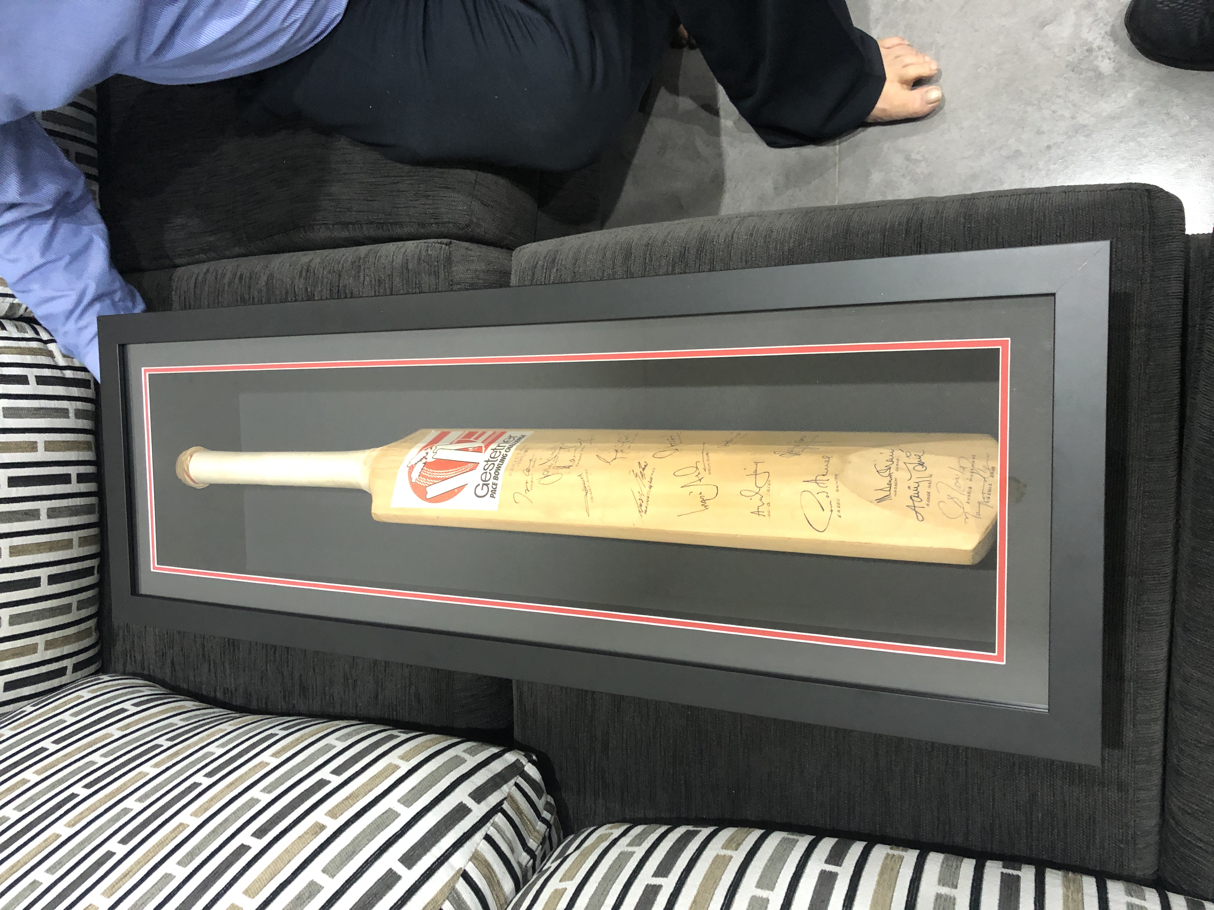 Signed full-size cricket bat in a slim black display frame